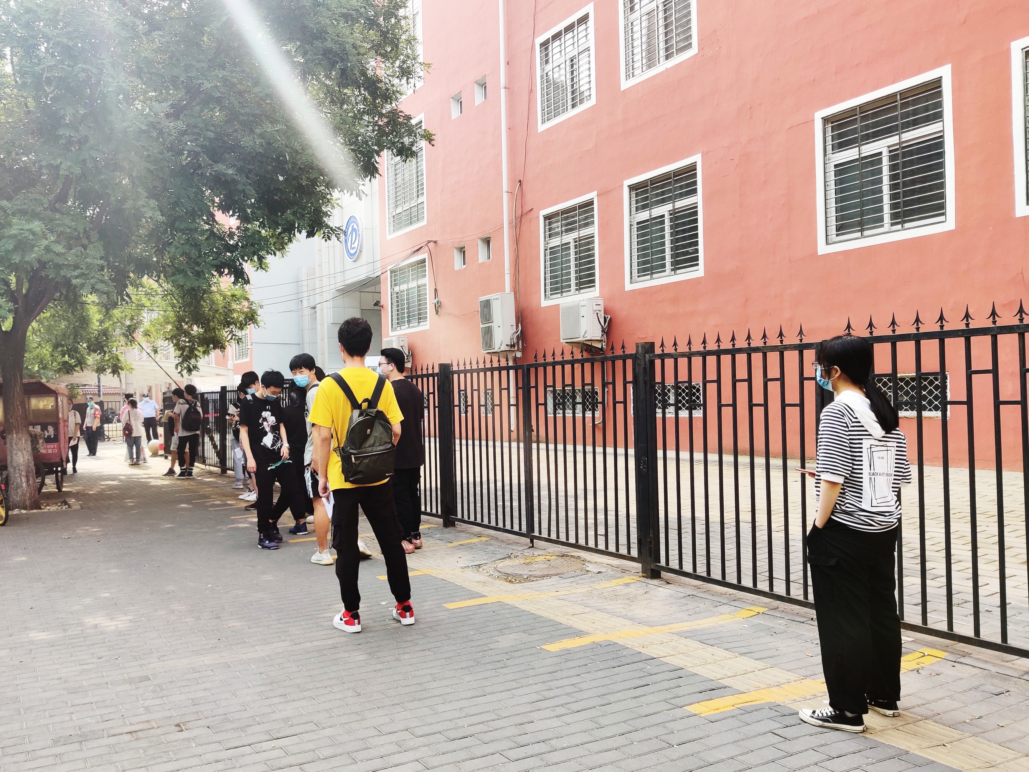 6月20日上午8时许，丰台区东铁匠营第一中学东校区考点外，参加第二场考试的考生在排队等待入场。
