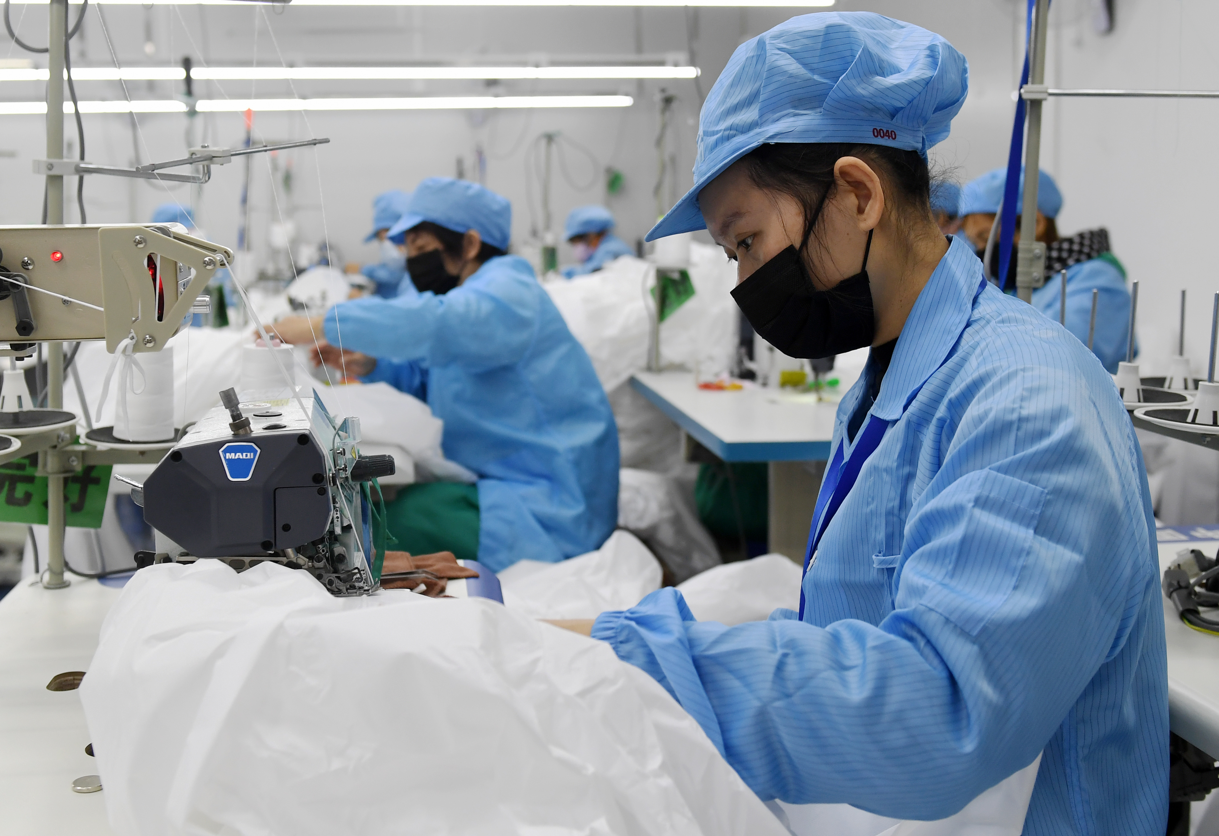 Workers make medical isolation gowns at a biotechnology company in Nanning, south China