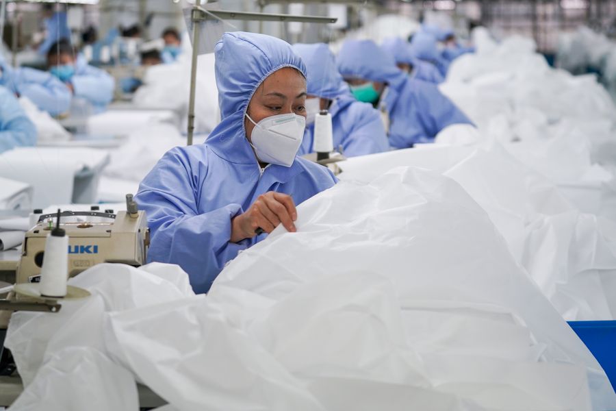 Workers make general protective suits at Hongdou Industrial Co., Ltd. in Wuxi, east China