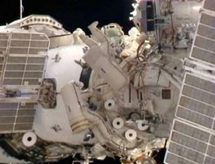 Flight engineer Mike Barratt (L) and Commander Gennady Padalka (R) work with cables on the docking antenna during their spacewalk from the International Space Station in this image from NASA TV June 5, 2009. (Xinhua/Reuters, File Photo)