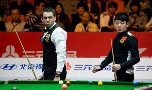 Ronnie O'Sullivan (L) of England reacts during round one of 2010 World Snooker China Open against Tian Pengfei of China in Beijing, capital of China, March 31, 2010. Tian won 5-3. (Xinhua/Yang Lei)