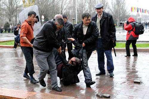 Protestors carry an injured fellow in Bishkek, capital of Kyrgyzstan, April 7, 2010. (Xinhua/Sadat)