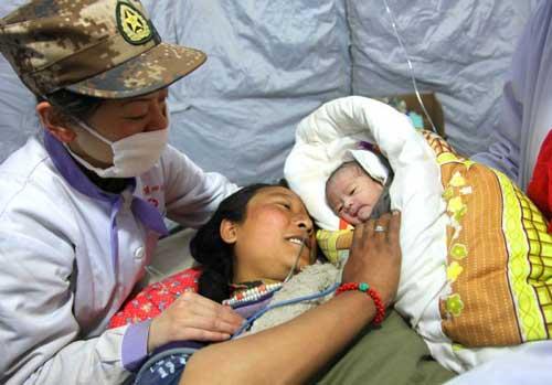 Ga Yong (C), a 22-year-old woman who just gave birth to a baby girl in a tent hospital, looks at her daughter in Gyegu Town, northwest China's Qinghai Province, on April 17, 2010. (Xinhua/Li Gang)