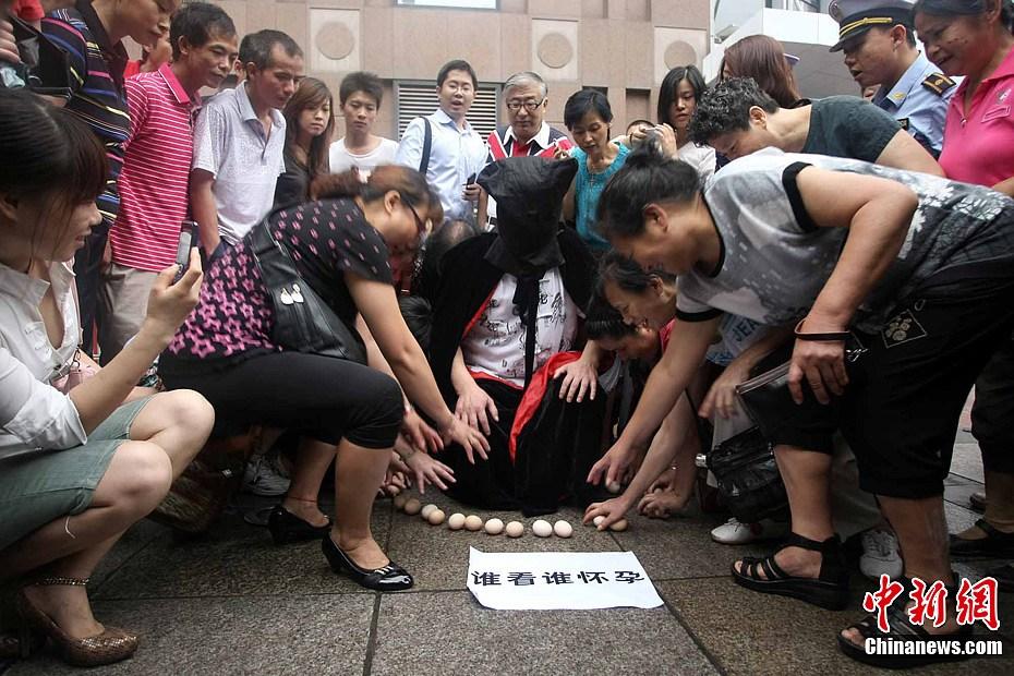 重庆现<em>蒙面</em>男子街头孵蛋 引中年妇女追捧(图