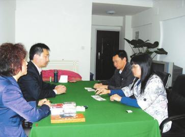 佀国旗和程娟在接待一对深陷赌瘾的夫妻(右一、右二)。