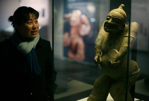 A visitor looks at a standing figure from the Eastern Han Dynasty