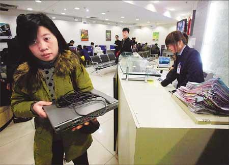 A woman collects her notebook computer from an HP repair shop in Zhongguancun.