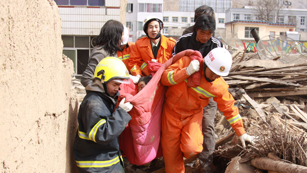 2010年4月14日上午11时3分，参谋长王景超（中间）、参谋王启虎（左一），战士韩蒙蒙（右一）和张鸣岗（最后），扎西桑周以及两位路过的藏族小伙一起，用一条棉被将获救的江嘎抬出，并在路边拦了一辆自发救人的面包车，将江嘎送到了医院。
