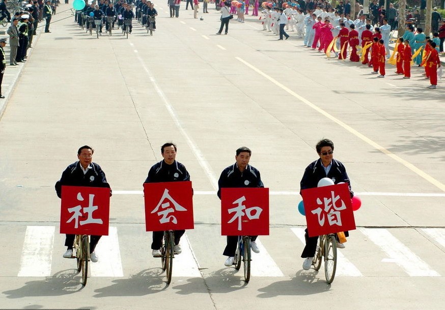 2006年4月30日，江苏淮安市举办第一届全民健身运动会万人自行车巡游活动，四位淮安市民族宗教事务局的干部打出“社会和谐”标语。