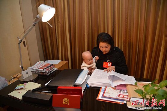 2012年11月10日晚，北京，四川省代表团驻地。四川省出席党的十八大代表中最年轻的代表罗玮参加完四川团的会议，回到驻地房间一边继续阅读学习大会的有关材料，一边照顾已有睡意的女儿。