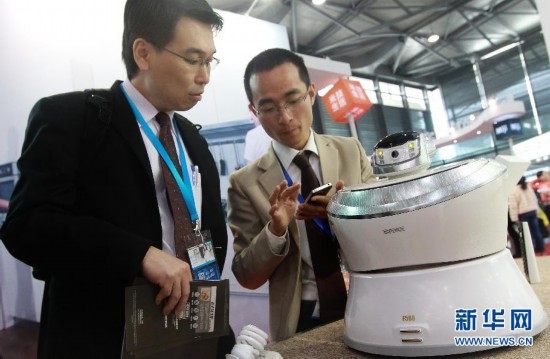 3月19日，一名工作人员（右）向参观者演示一台可以通过手机遥控的空气净化器。新华社记者裴鑫摄