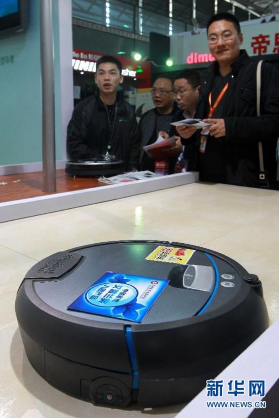 3月19日，参观者在博览会上观看一台清扫机器人的功能展示。新华社记者裴鑫摄