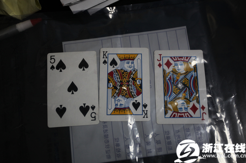 在尸体身边，有三张扑克牌：黑桃5、方块J、黑桃K。
