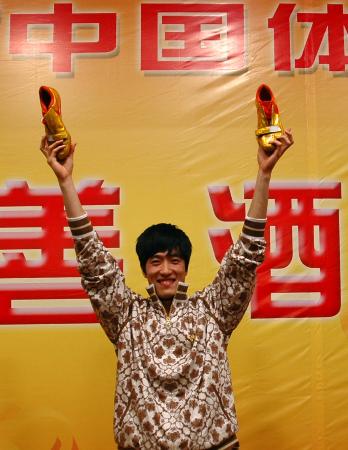 刘翔高举自己设计的球鞋
