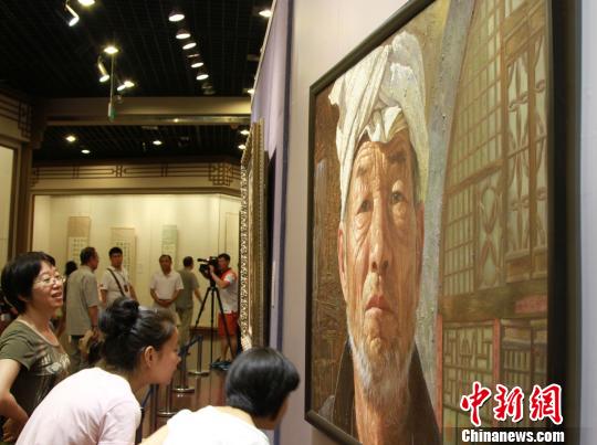 图为观众在欣赏辽宁画家张洪赞的油画《岁月留痕》。　司晓帅　摄