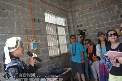 　　新胜屯村民马金梅正在向采访团介绍自家的沼气池。 广西新闻网记者叶焱焱 摄