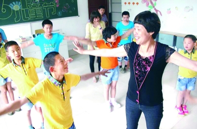 教学生做游戏，王渭仙希望他们每个人都有属于自己的快乐。资料照片