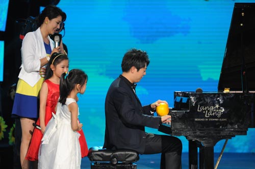 国际知名钢琴家郎朗向孩子们展示用水果弹奏钢琴的绝活