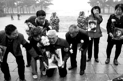 抗美援朝烈士纪念碑前，满头白发的志愿军烈士后人跪拜在地。京华时报记者朱嘉磊摄