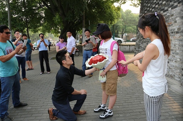 图说:男子下跪求婚,拿花女生为"萌萌.网络图