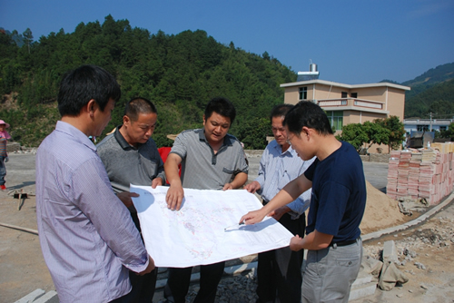 苏志刚和村干部在研究新村规划