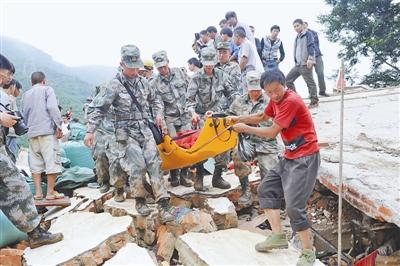 8月4日，第14集团军某部官兵从瓦砾堆中紧急抢救伤员