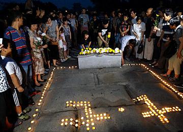 图为7月6日，北京卢沟桥，人们点燃蜡烛缅怀抗战先烈。