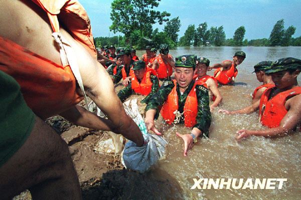 这是解放军济南军区某部官兵跳入洪水中在荆江大堤险段抢险(资料照片)。