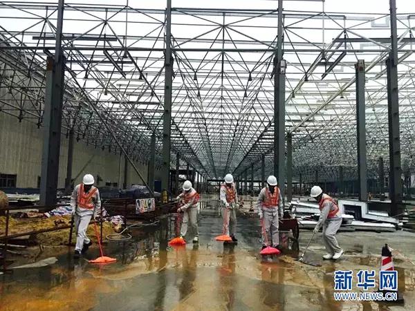 图为广汽乘用车二线总装施工场地，党员带头清洁在建厂房。