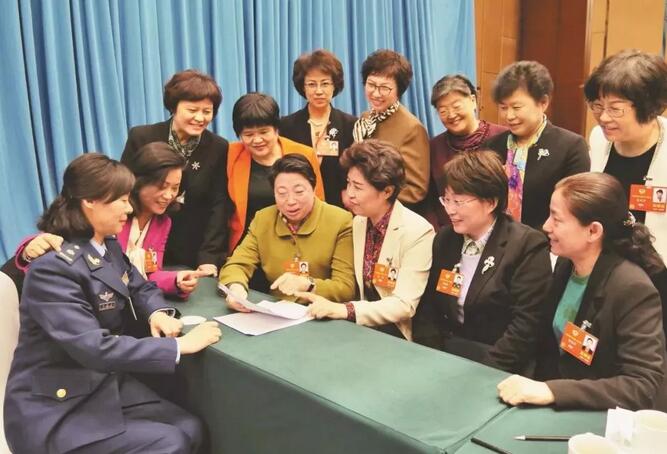 3月6日，在全国政协十三届一次会议医卫界别委员联组会议结束后，女委员们聚在一起讨论政府工作报告中关于实施健康中国战略的内容。  记者 彭景晖摄