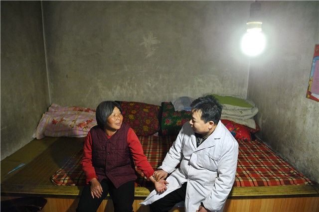 在河北省唐县白合镇上庄村，家庭签约医生李少达（右）在为村民闫爱琢把脉（3月13日摄）。 