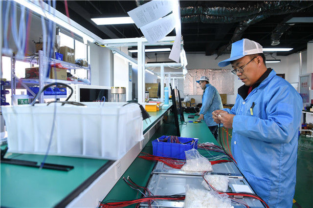 在保定涿州·中关村和谷创新产业园，范宏浩团队的工作人员在组装电子产品（3月12日摄）。 