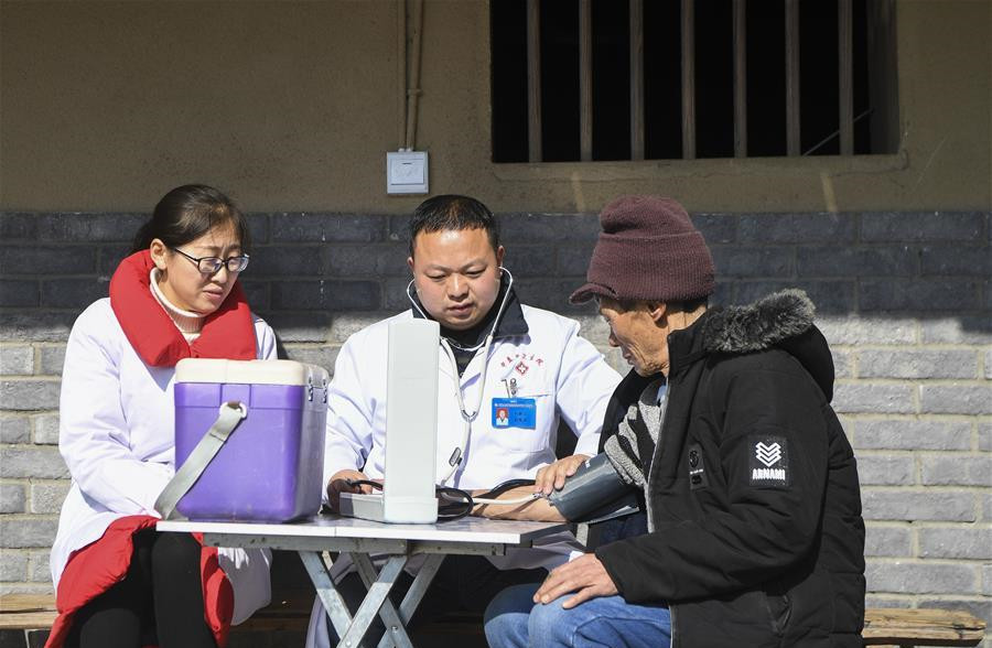 重庆市石柱土家族自治县中益乡卫生院的医护人员为华溪村村民谭登周测量血压