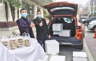 郝乐（左）和大厨温伟波（右）往医院送免费盒饭