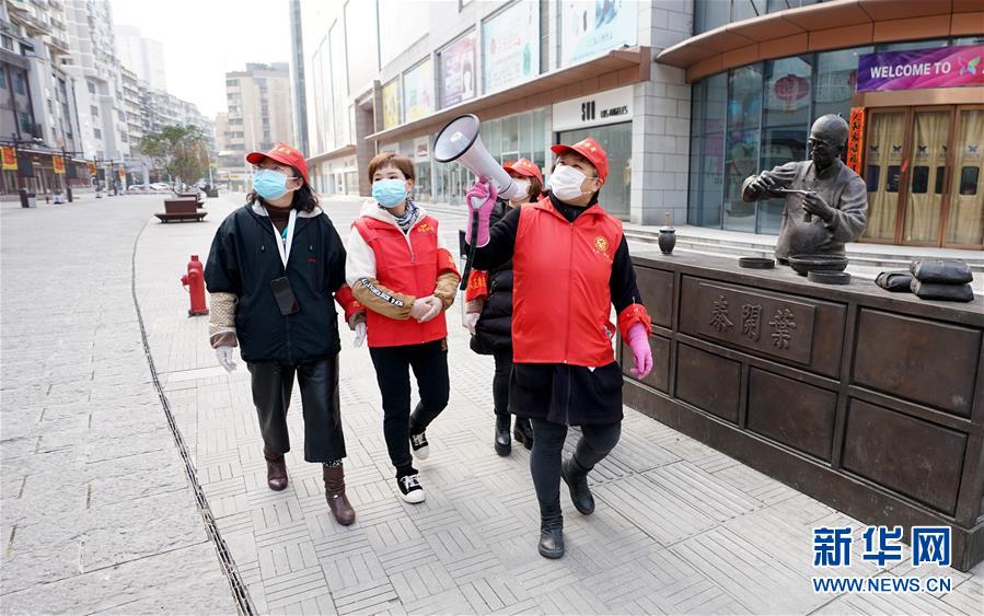 武汉市汉正街石码社区党委书记兼居委会主任韩小琴（右一）带领社区工作人员向步行街旁的居民宣传防疫知识（2月13日摄）。 新华社记者 王毓国 摄
