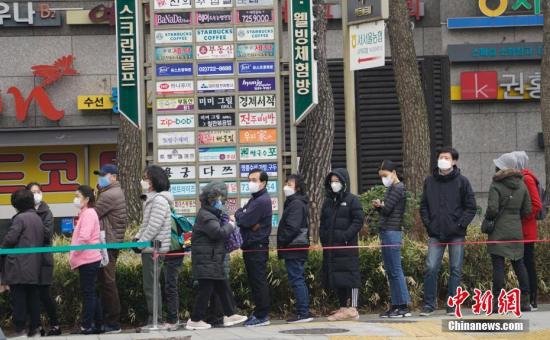 3月1日，在首尔钟路区一家超市外，民众排起长队等待购买口罩。中新社记者 曾鼐 摄