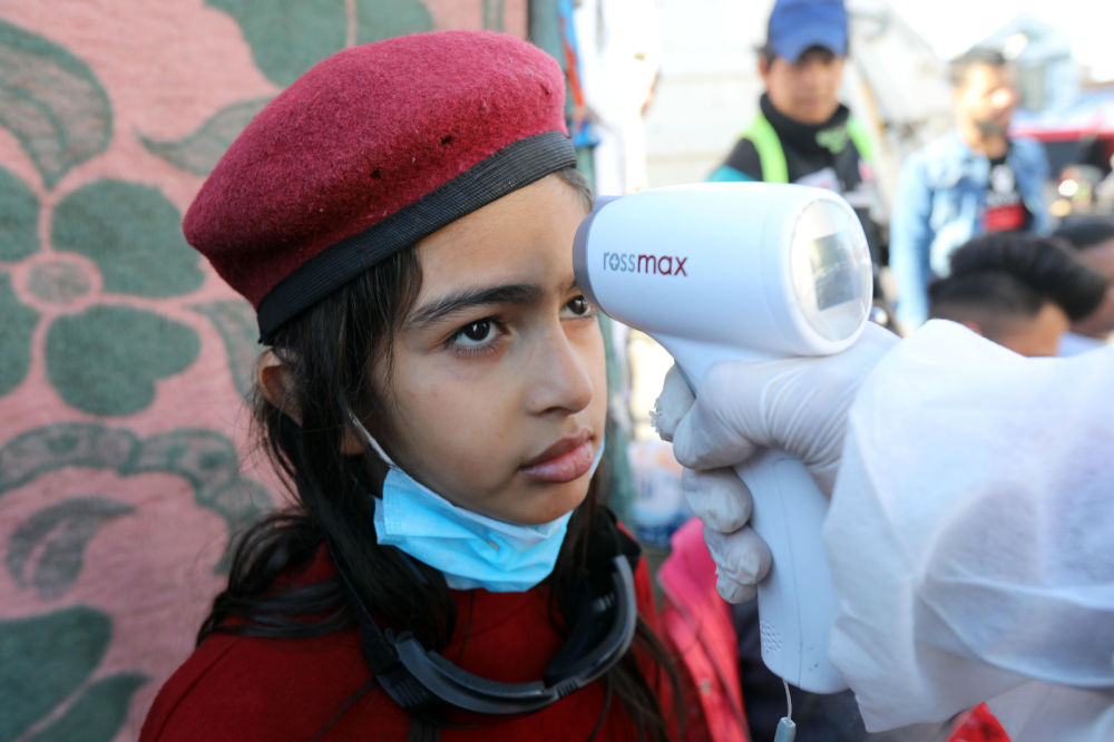 3月2日，在伊拉克巴格达解放广场，一名女孩接受体温检测。新华社发（哈利勒·达伍德摄）