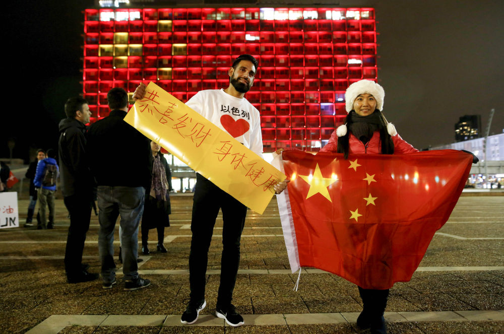 2月11日，在以色列特拉维夫市政大楼前，在以华人和以民众表达对中国的祝福。新华社发（吉尔·科恩·马根摄）
