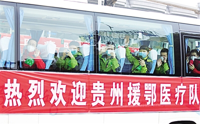 3月19日，贵州省第七批援鄂医疗队队员隔窗向欢迎队伍挥手，向家乡人民问好。张晖摄/光明图片