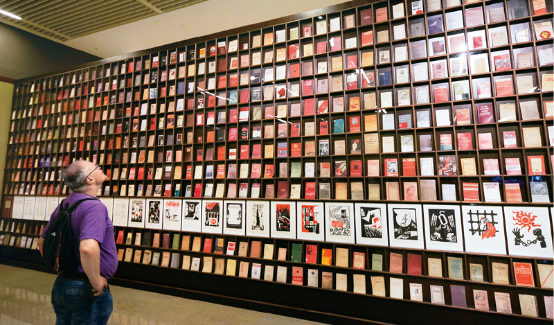 　　△2018年5月9日，一位外国观众被北京“真理的力量——纪念马克思诞辰200周年主题展览”中一面展示不同国家出版的500多种《共产党宣言》的书墙所吸引。