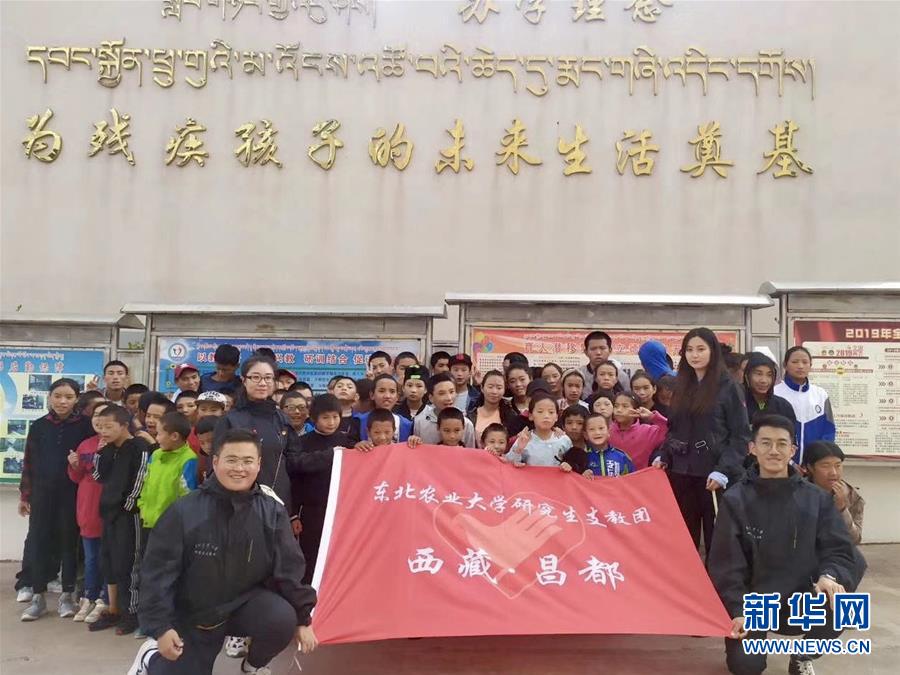 东北农业大学毕业生李明键（前排左一）与研究生支教团在西藏昌都市支教期间与学校师生合影（资料照片）。
