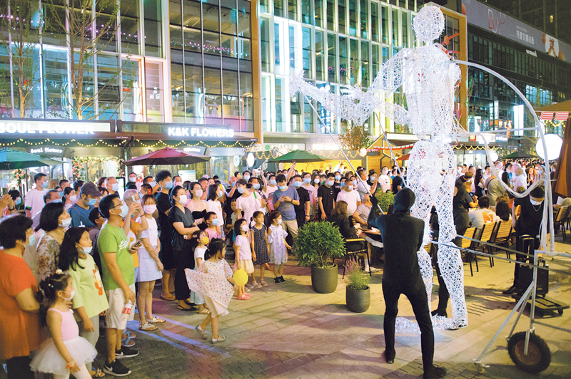　　2020年8月8日，北京市朝阳区的“潮朝阳”消费季活动正式重启。图为8日当晚，市民在望京小街商业街观看巨型人偶表演。　新华社记者　陈钟昊／摄