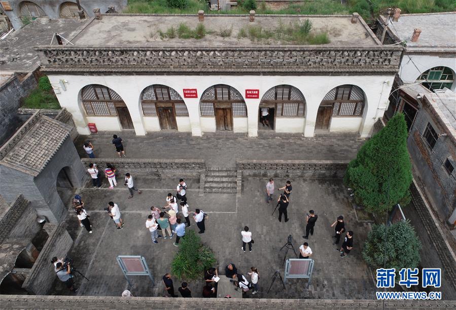 参加“记者再走长征路”活动的媒体记者在陕西省子长县瓦窑堡会议旧址采访（2019年8月9日摄，无人机照片）。新华社记者 罗晓光 摄