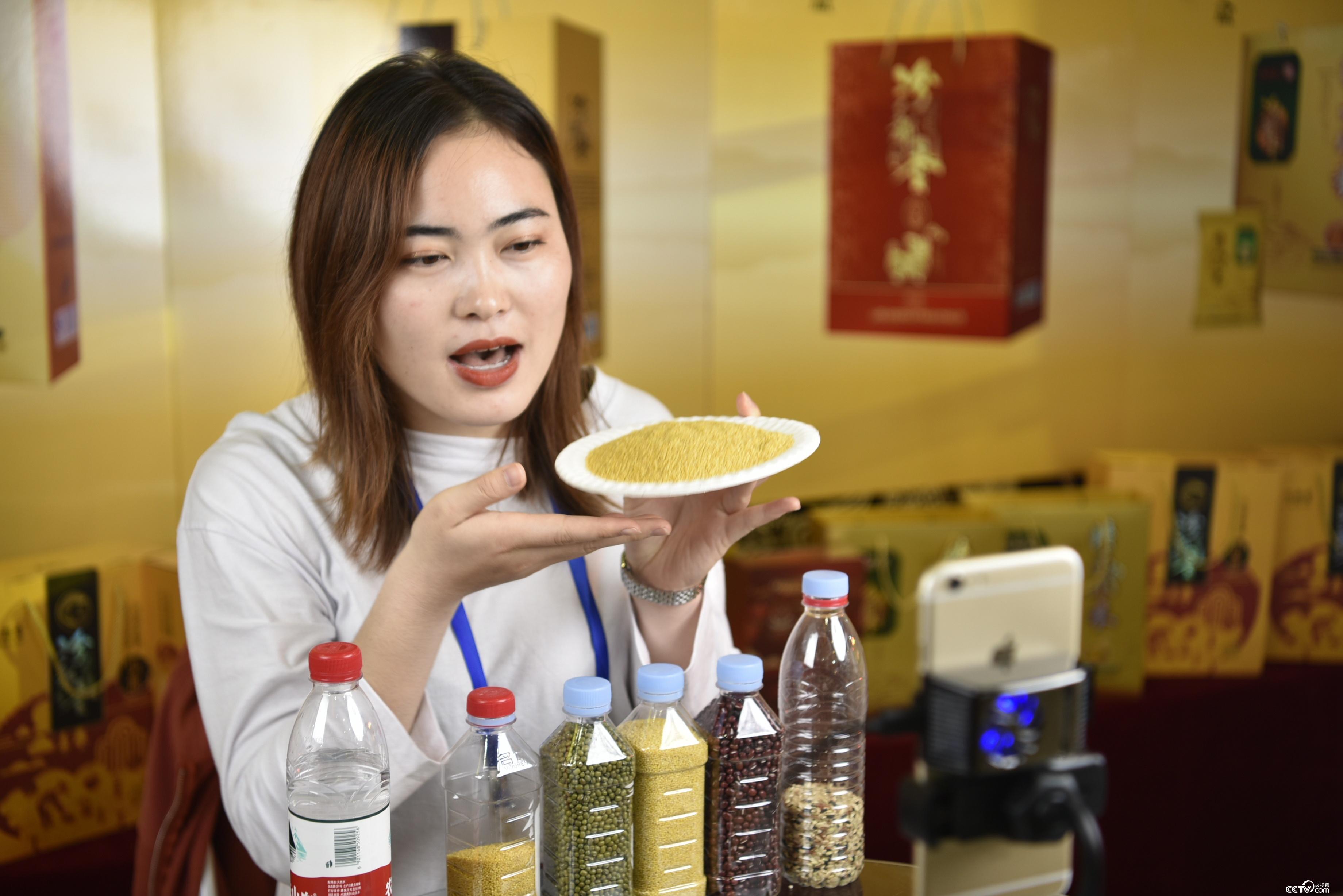 活动现场，欧博abg工作人员正在介绍山西的各种小杂粮产品。