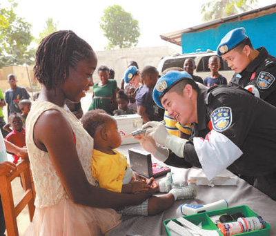 在利比里亚蒙罗维亚，中国第五支驻利比里亚维和警察防暴队医护人员进行义诊。