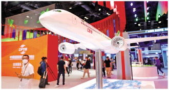 图为2022年中国国际服务贸易交易会国家会议中心展区现场。多位记者在C919客机模型旁观看拍照。 CFP供图