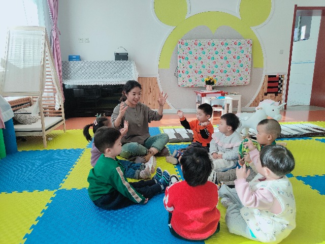 幼儿和老师一起做游戏 常海玲 摄