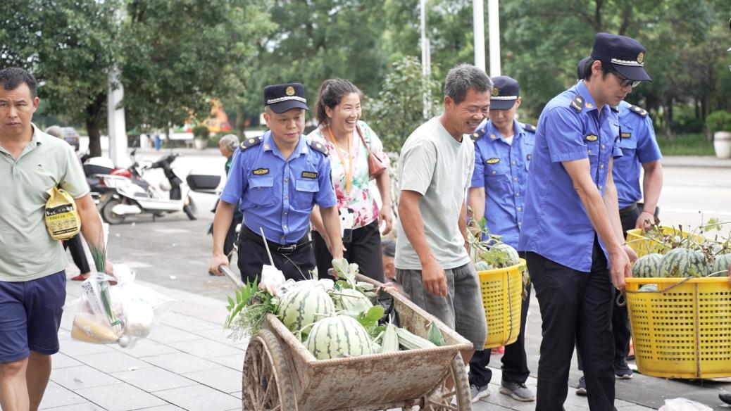 城管执法人员帮助摊主搬运东西到集中摊位点(周珍萍/摄)