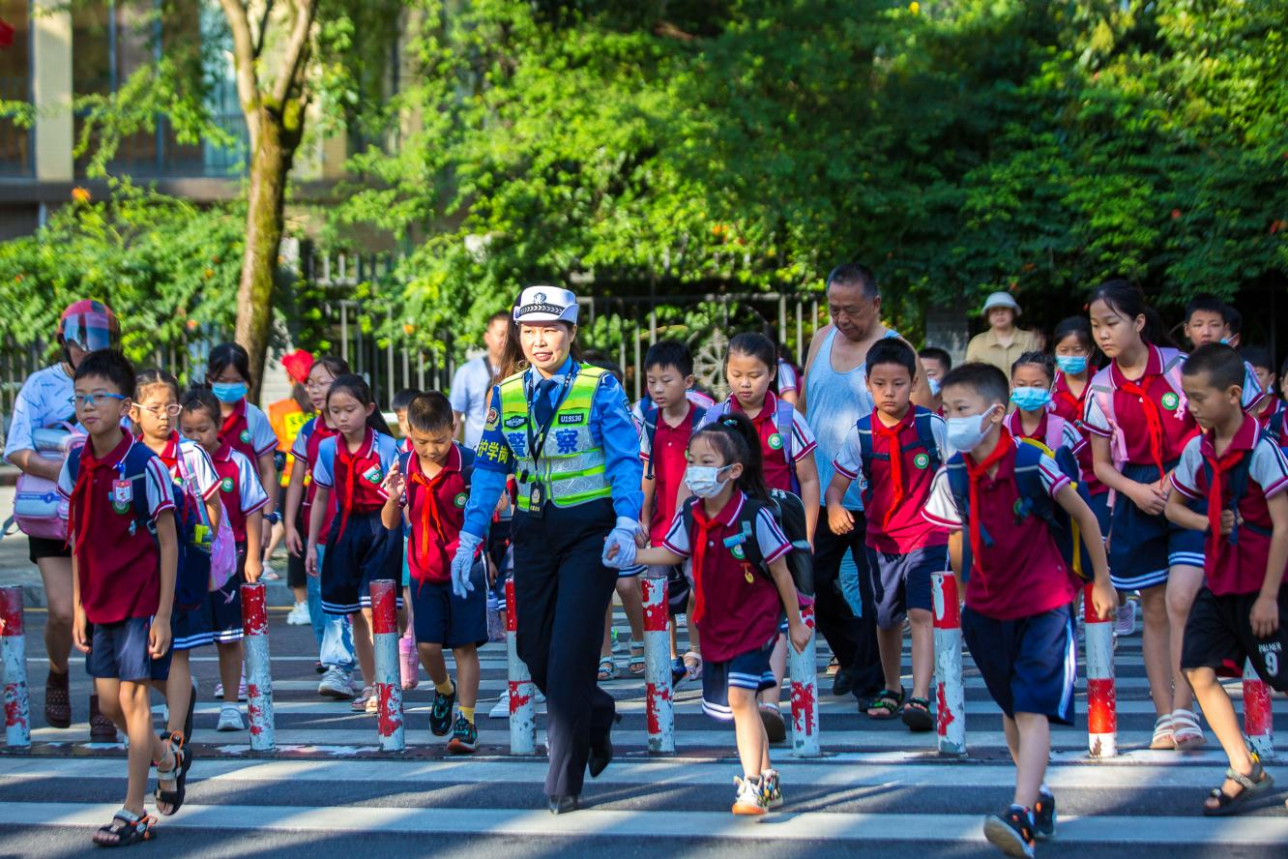 吉首市第八小學上學高峰期,市公安局交警大隊“女子護學崗”民警引導學生們安全過馬路。