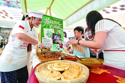 消费者在江苏泰州市海陵区万达广场“跟着苏超游徐州”徐州文旅(泰州)推介会上品尝食品。新华社发